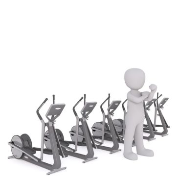man in shadow, standing in front of workout equipment.
