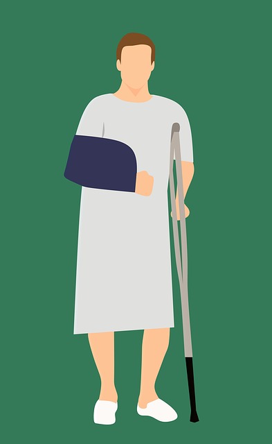 man in hospital gown with a sling and a cane